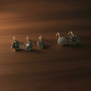 Discover the charm of our oxidized silver designer nose pins, specially crafted in a pack of 5 to enhance your ethnic beauty with elegance and style. Each nose pin features a unique design inspired by floral, geometric, and textured motifs that offer a rich antique silver finish, perfect for women and girls who appreciate minimal yet classy traditional jewelry. Made from premium quality oxidized alloy, these nose pins are lightweight, skin-friendly, and provide a comfortable fit for all-day wear. Whether for daily use, festive occasions, weddings, or gifting, these lightweight, comfortable nose pins securely grip and complement both ethnic and fusion outfits beautifully.